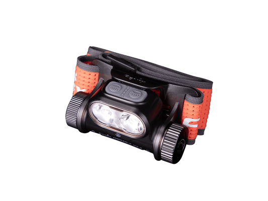 Robuste Stirnlampe mit zwei LED-Leuchten und orange-grauem verstellbarem Kopfband vor schwarzem Hintergrund