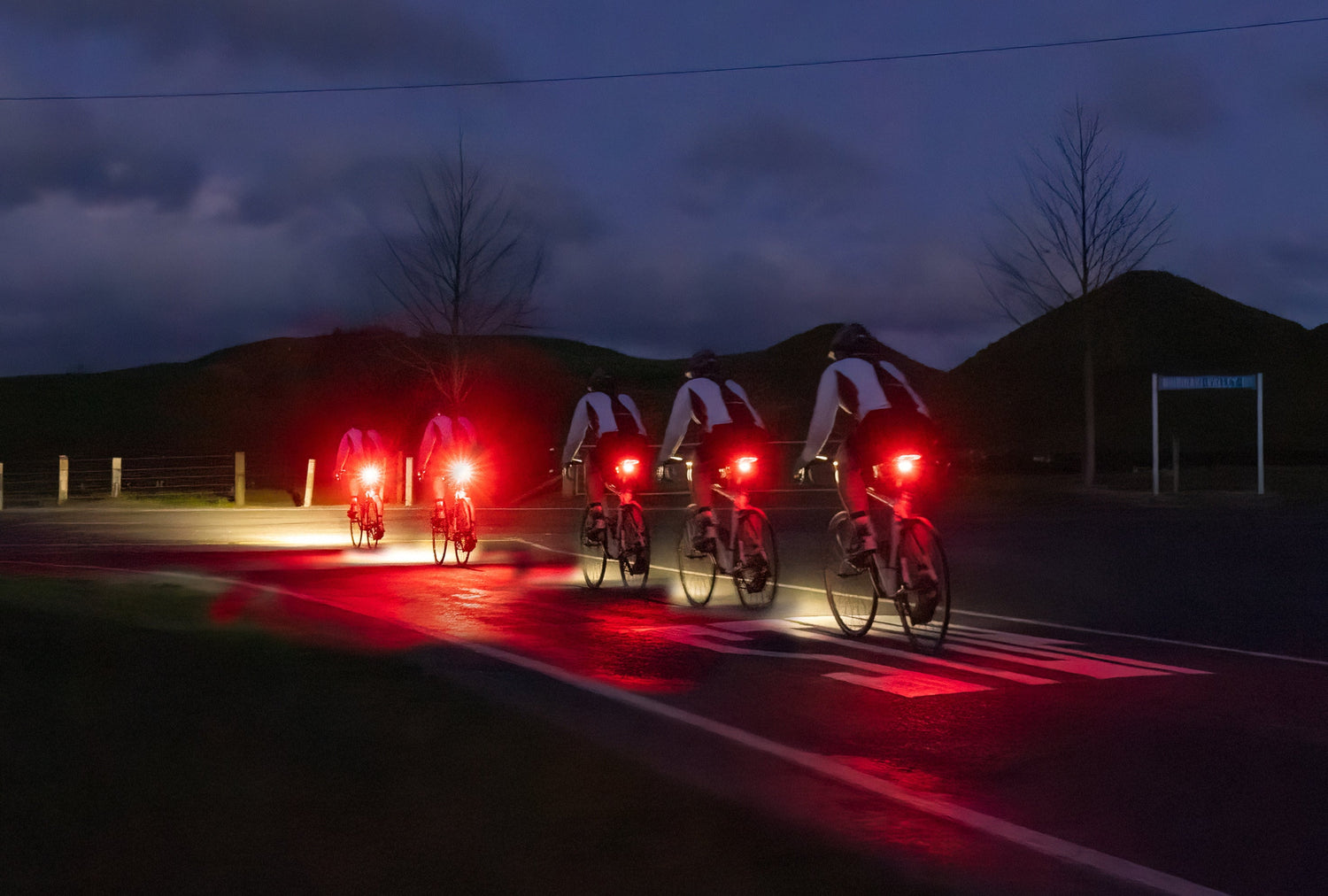 Mann mit rotem Helm und Fahrrad in Regen bei Nacht mit heller Fenix Fahrradbeleuchtung im Wald
