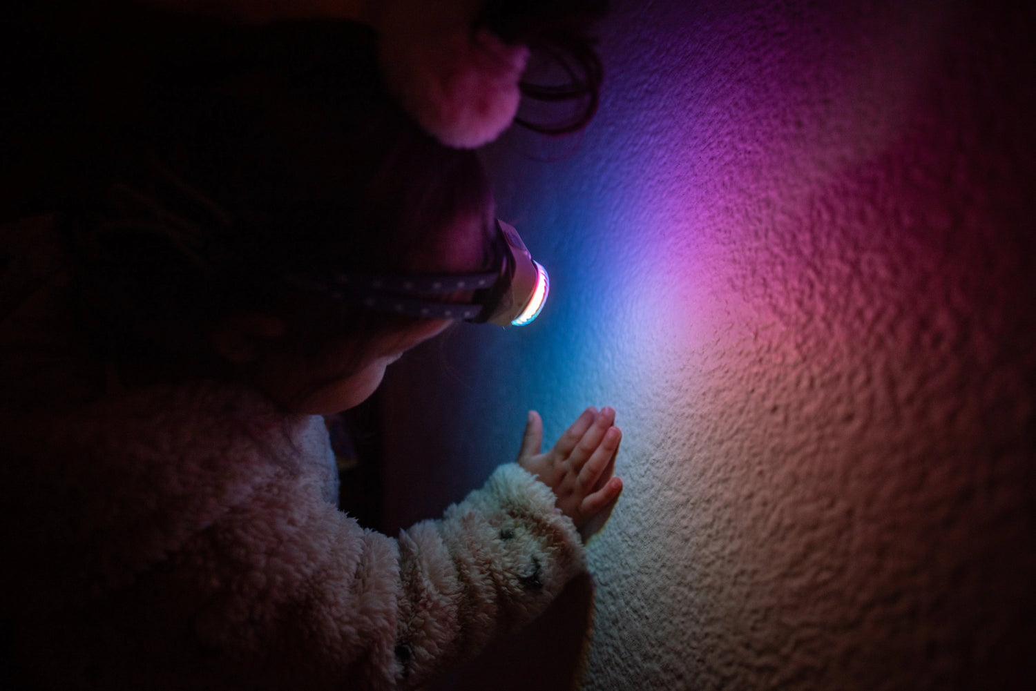 Mann mit Fenix-Taschenlampe liest Karte im dunklen Wald, Rucksack am Boden, Outdoor-Szene