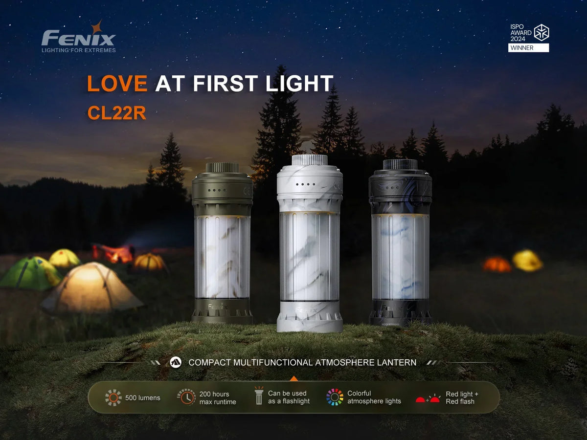 Drei Fenix CL22R Campinglaternen in verschiedenen Farben vor einem Zeltlager bei Nacht.