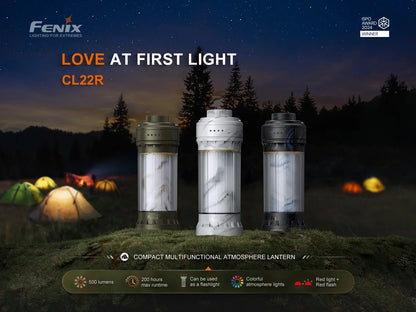 Drei Fenix CL22R Campinglaternen in verschiedenen Farben vor einem Zeltlager bei Nacht.