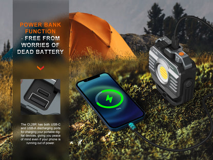 Fenix CL28R Outdoor LED-Lampe mit Powerbank-Funktion lädt Smartphone neben orangefarbenem Zelt im Wald