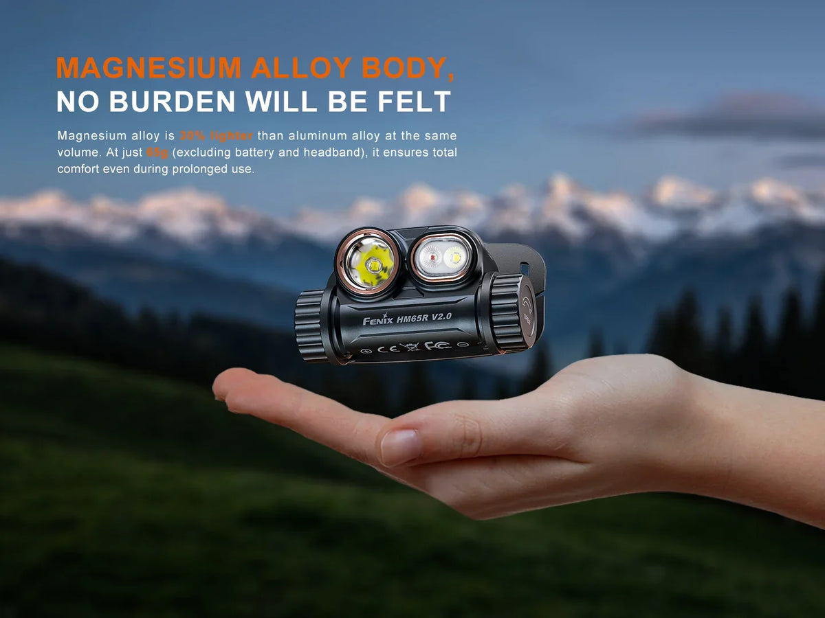 Fenix HM65R V2.0 Stirnlampe aus Magnesiumlegierung auf einer Hand vor Berglandschaft