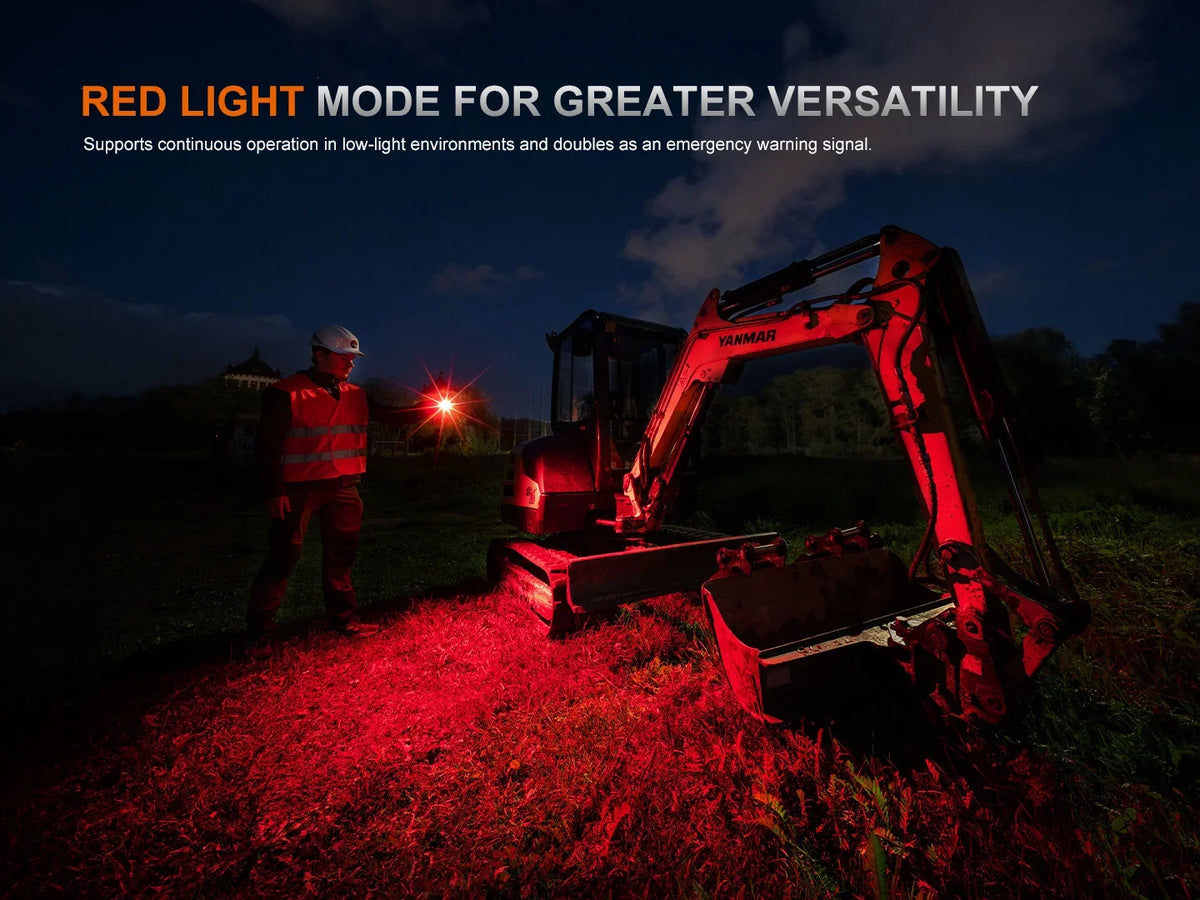 Arbeiter nutzt Fenix Stirnlampe im Rotlichtmodus neben einem Bagger bei Nacht.