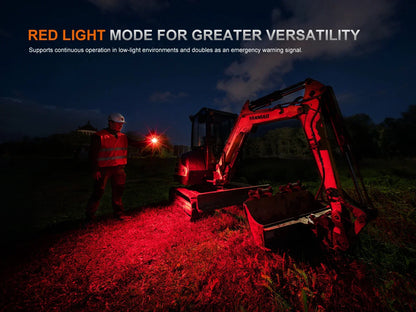 Arbeiter nutzt Fenix Stirnlampe im Rotlichtmodus neben einem Bagger bei Nacht.